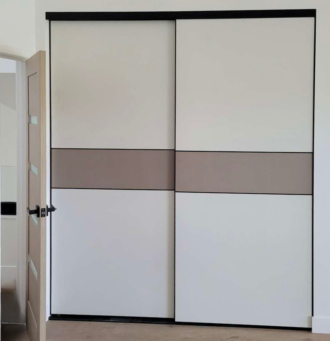 Two-tone sliding closet doors installed, black frame