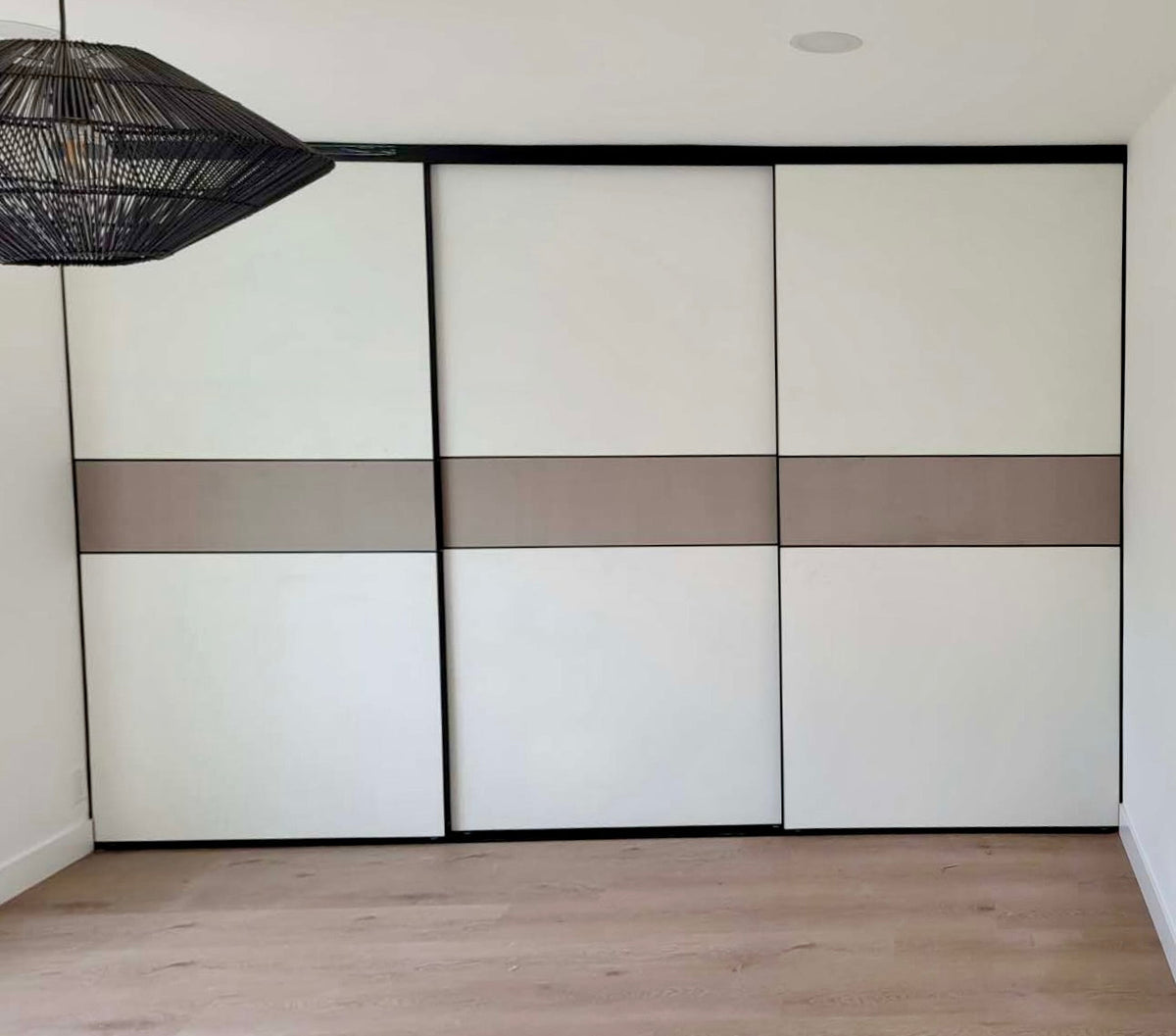 Wide closet with three two-tone sliding door panels