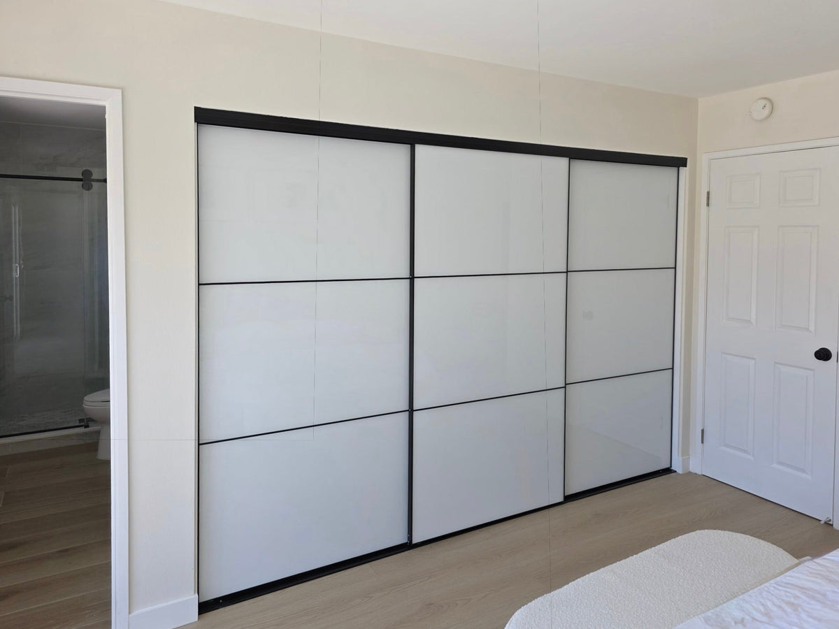 Wide closet opening with white glass sliding doors