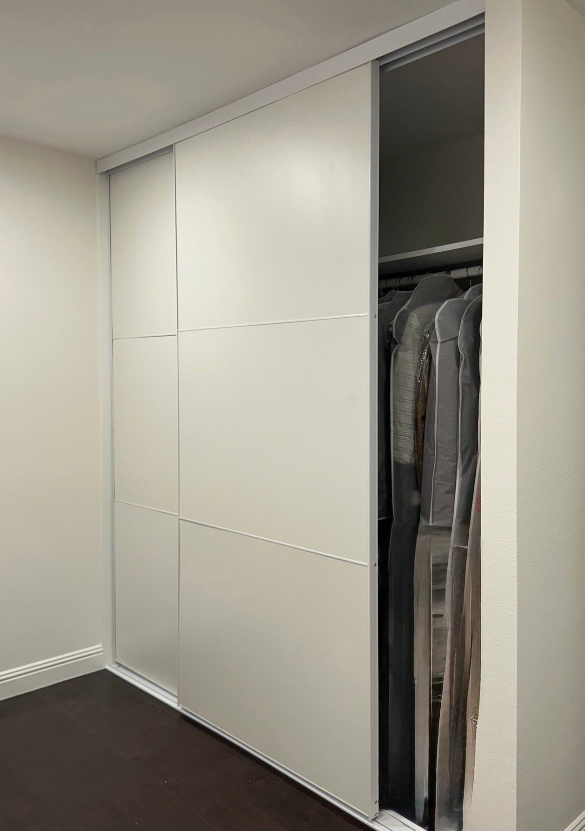 White panel bypass closet door slid open to a walk-in closet