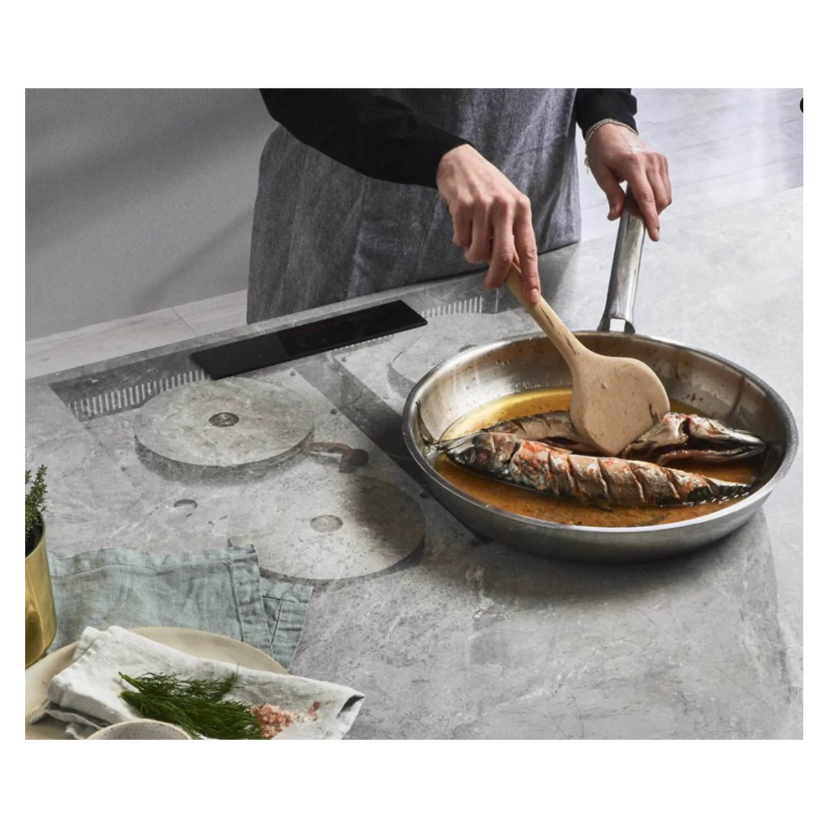 Invisacook hidden induction cooktop under a marble-look porcelain counter with flush controller